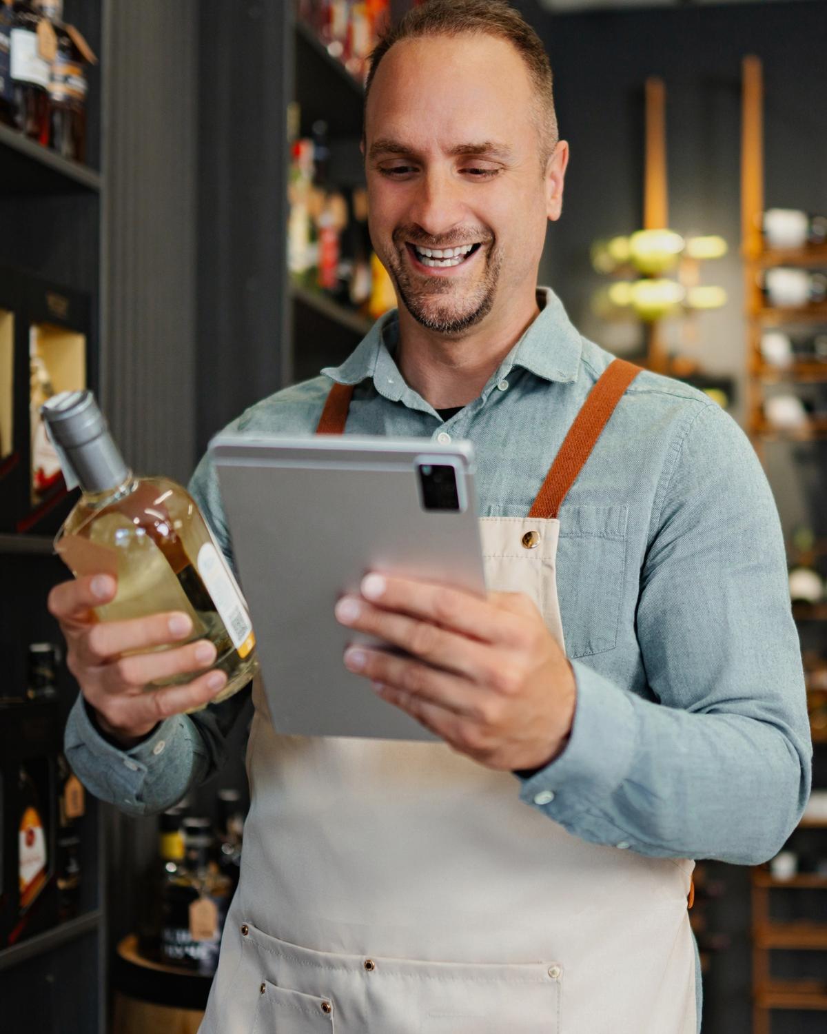 A beverage merchant reviewing stock on a tablet